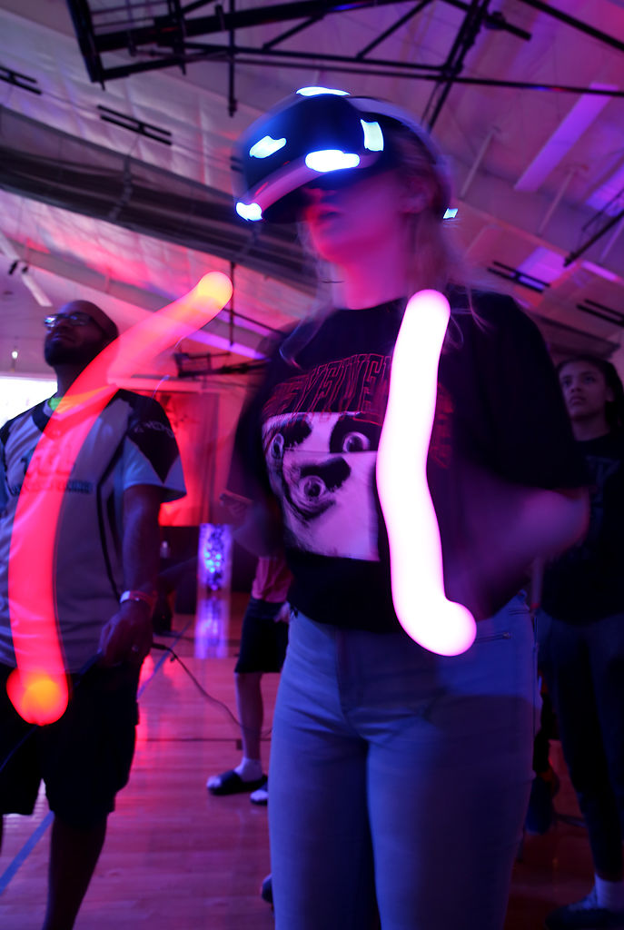 Adrianne Thompson slashes at virtual blocks while playing Beat Saber